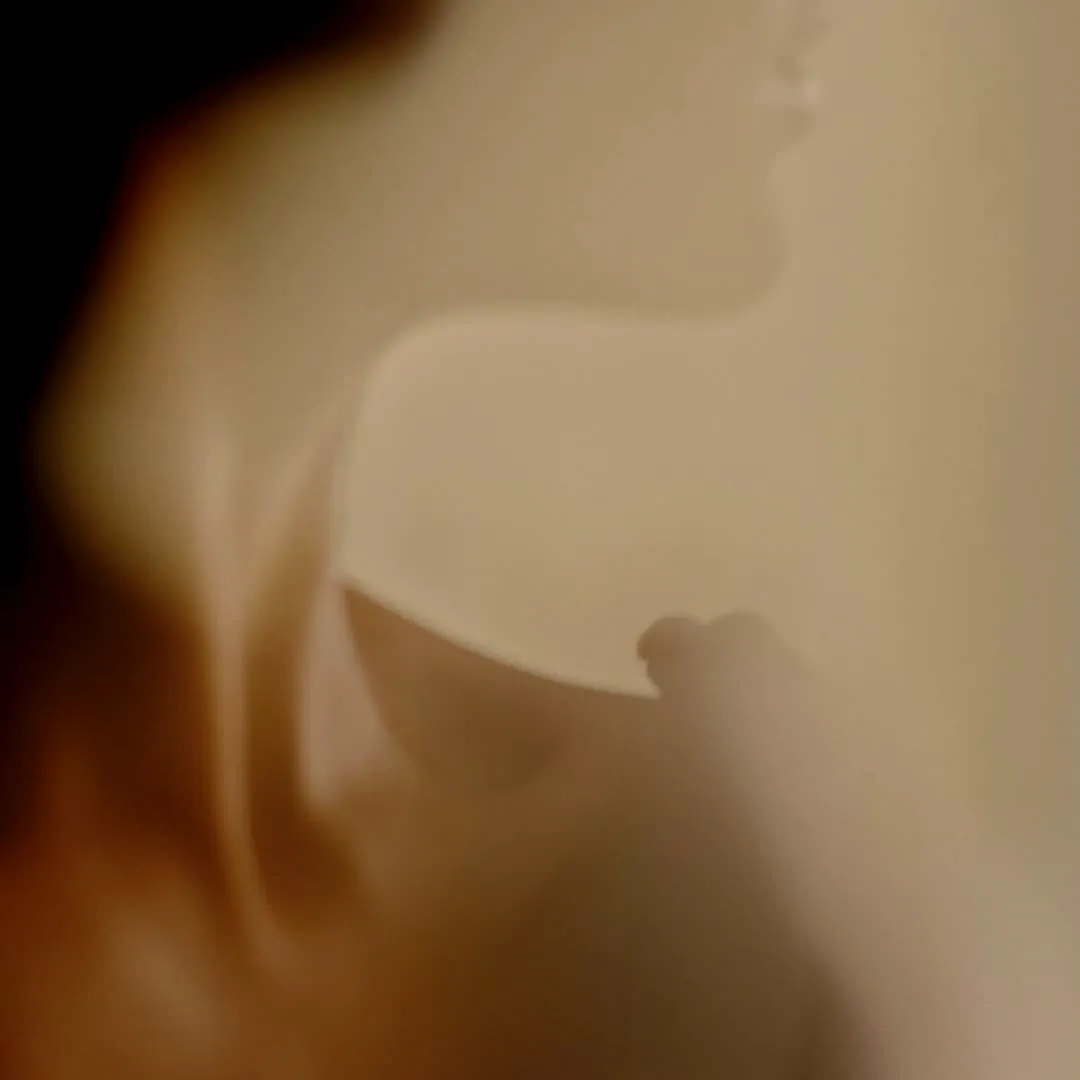A client's face and neck in profile, softly out of focus in warm light, during a facial at Millán